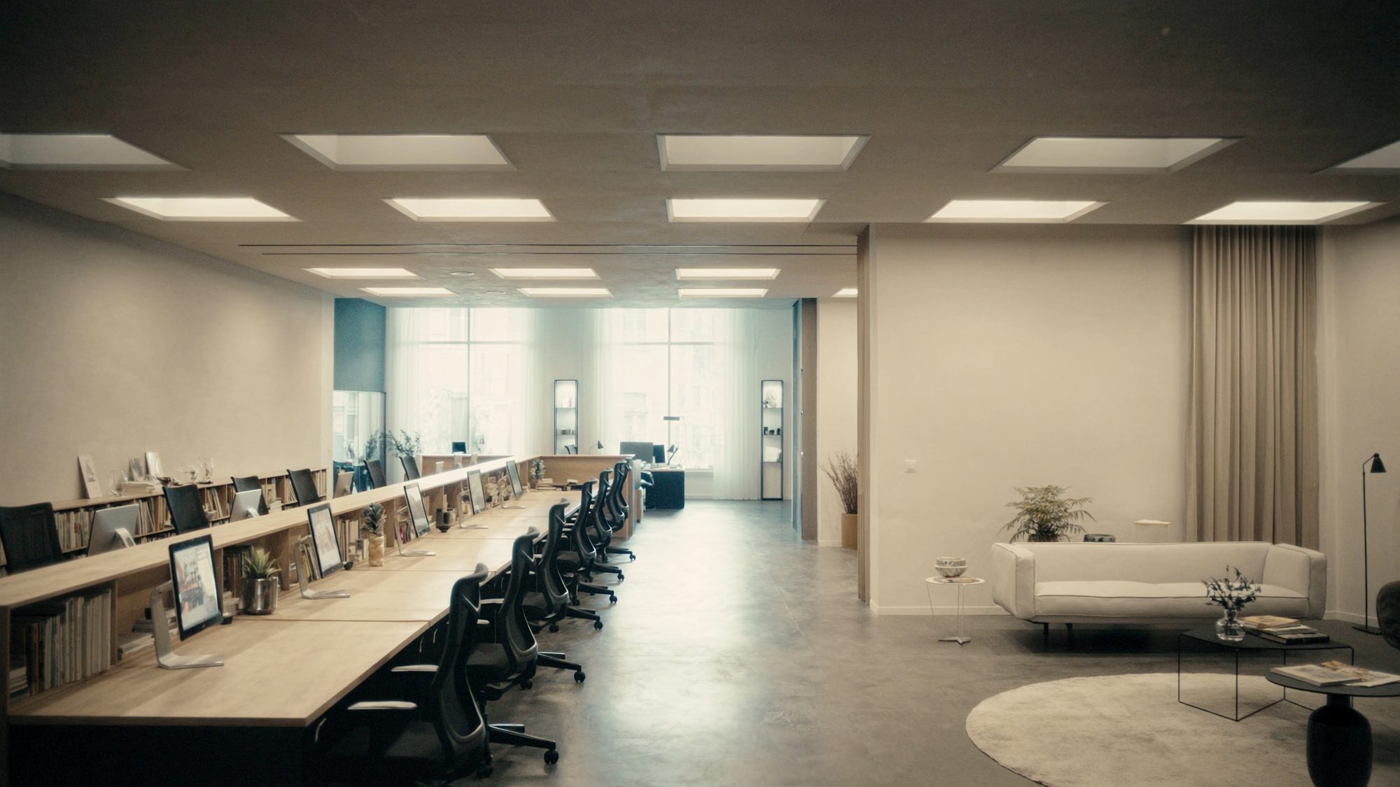 Open plan office with long shared benching desks in light oak