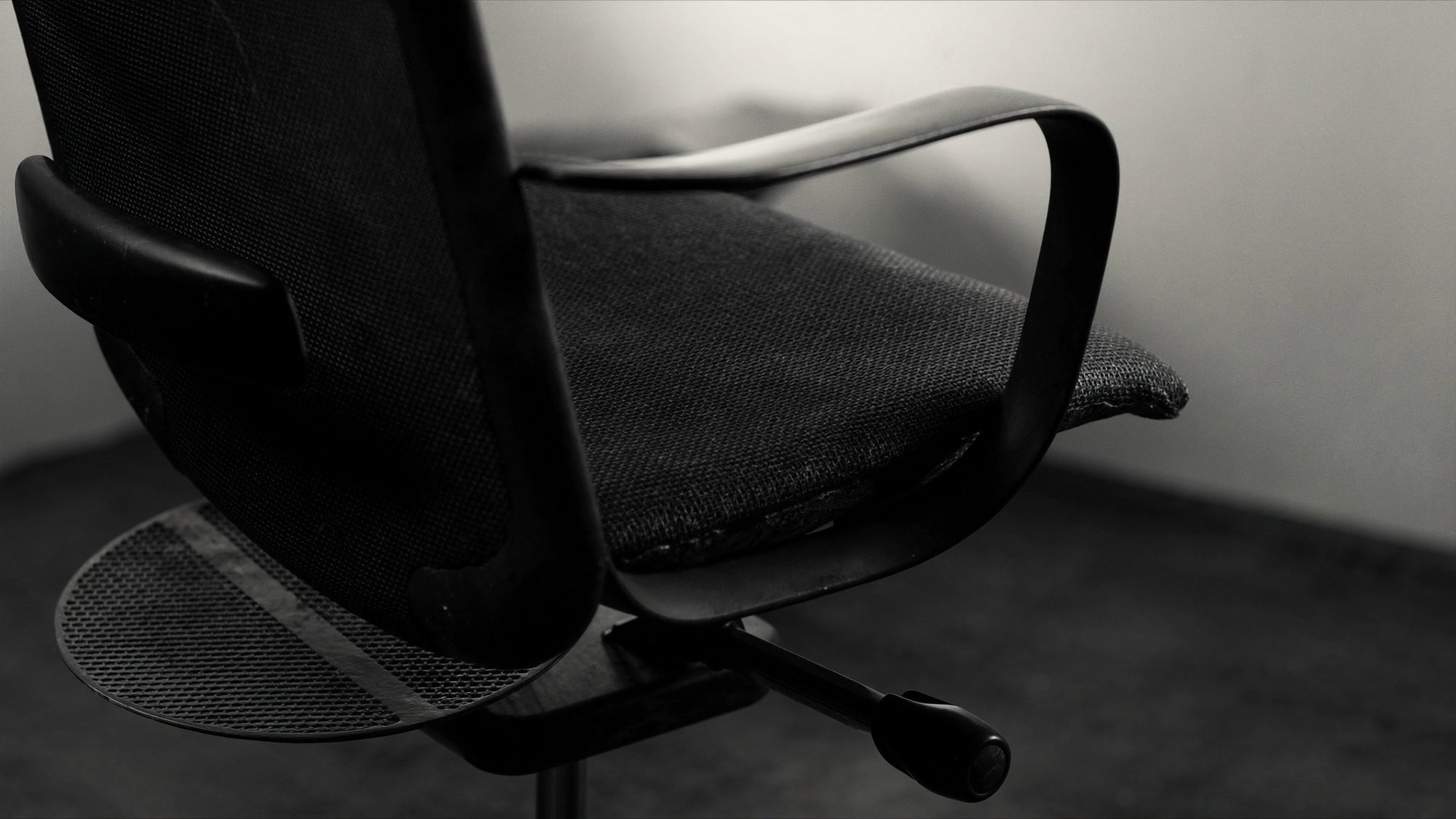 Detail of a modern office task chair in mesh and cast aluminium